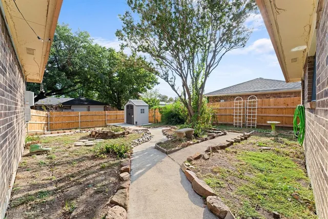 a view of a backyard that has a tree on the side of it