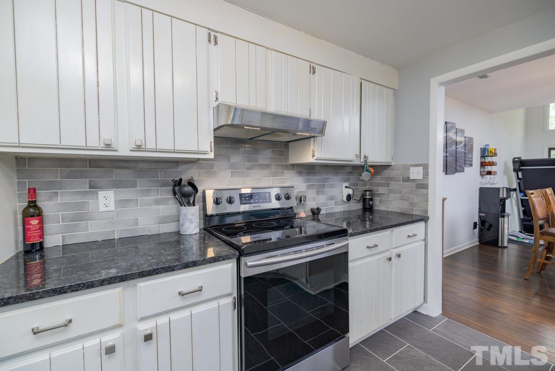 4415 Shadetree Court Raleigh, NC 27613 - Photo 8 of 23 a kitchen with granite countertop a sink stainless steel appliances and cabinets