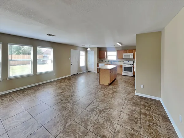 a view of a kitchen with fridge and window