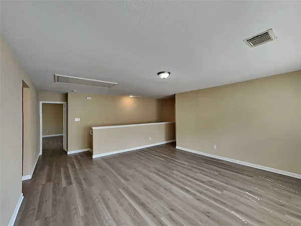 a view of an empty room with wooden floor