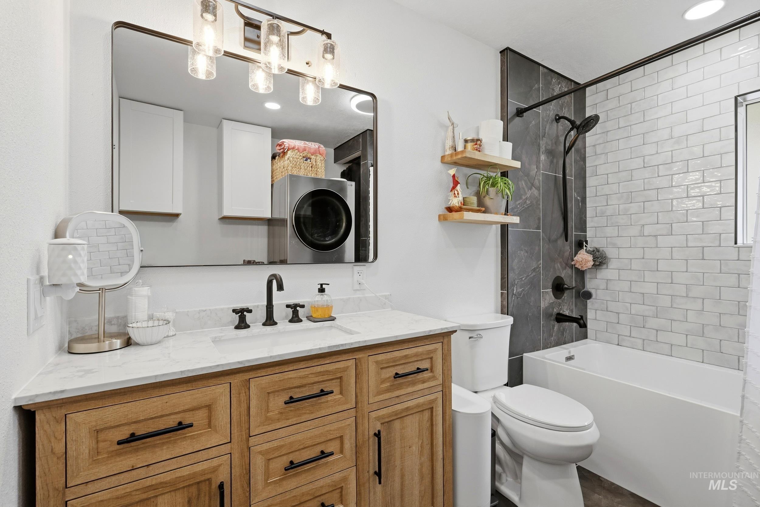 1803 14th Street Lewiston, ID 83501 - Photo 17 of 27 Wood-finish vanity with a light-toned countertop, black faucet, and rectangular mirror