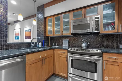 a kitchen with stainless steel appliances granite countertop a stove microwave and sink