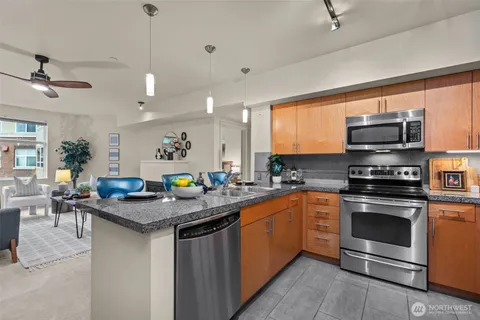 a kitchen with stainless steel appliances granite countertop a stove a sink dishwasher a microwave oven with granite countertops and cabinets