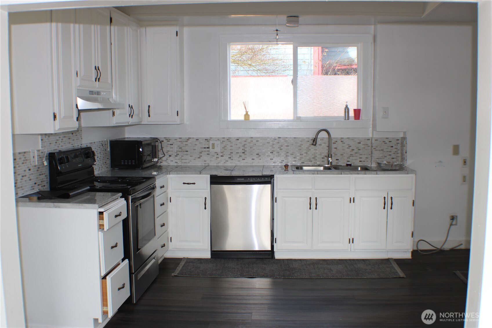 1224 4th Street Cosmopolis, WA 98537 - Photo 12 of 33 a kitchen with stainless steel appliances granite countertop a stove a sink and white cabinets