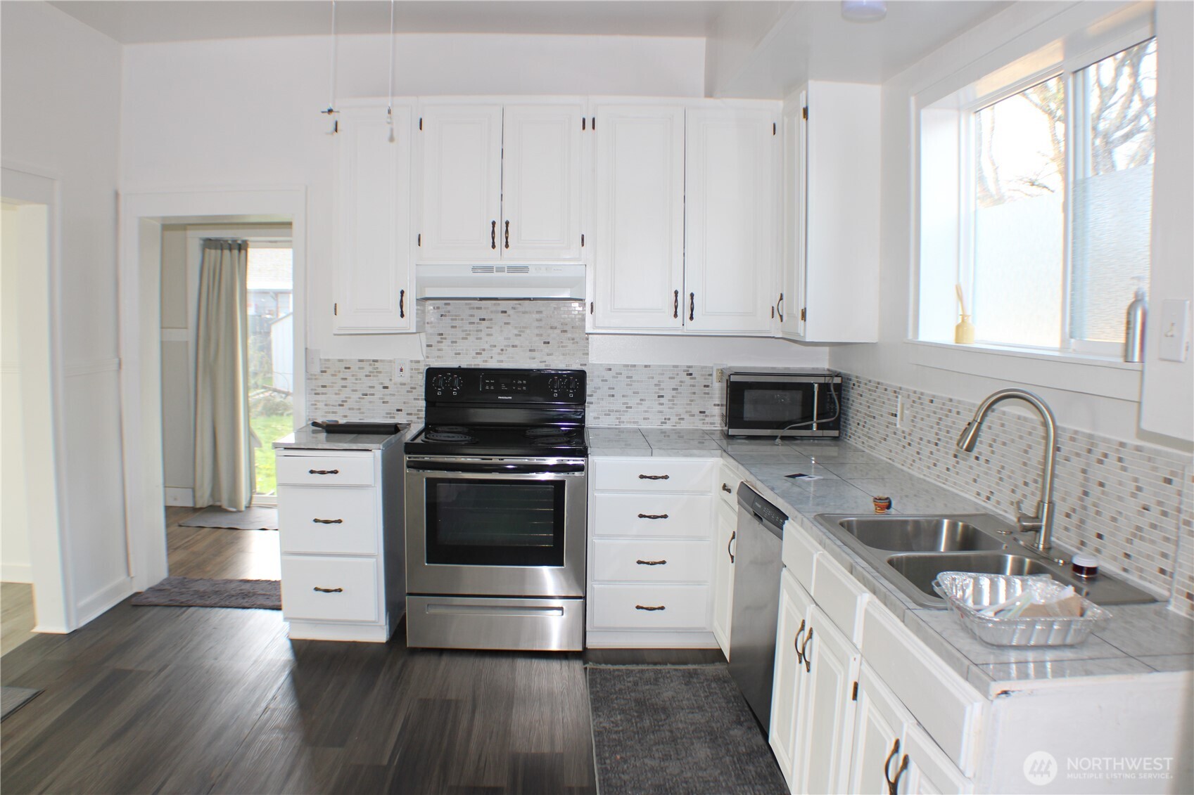 1224 4th Street Cosmopolis, WA 98537 - Photo 9 of 33 a kitchen with granite countertop a sink stove and cabinets