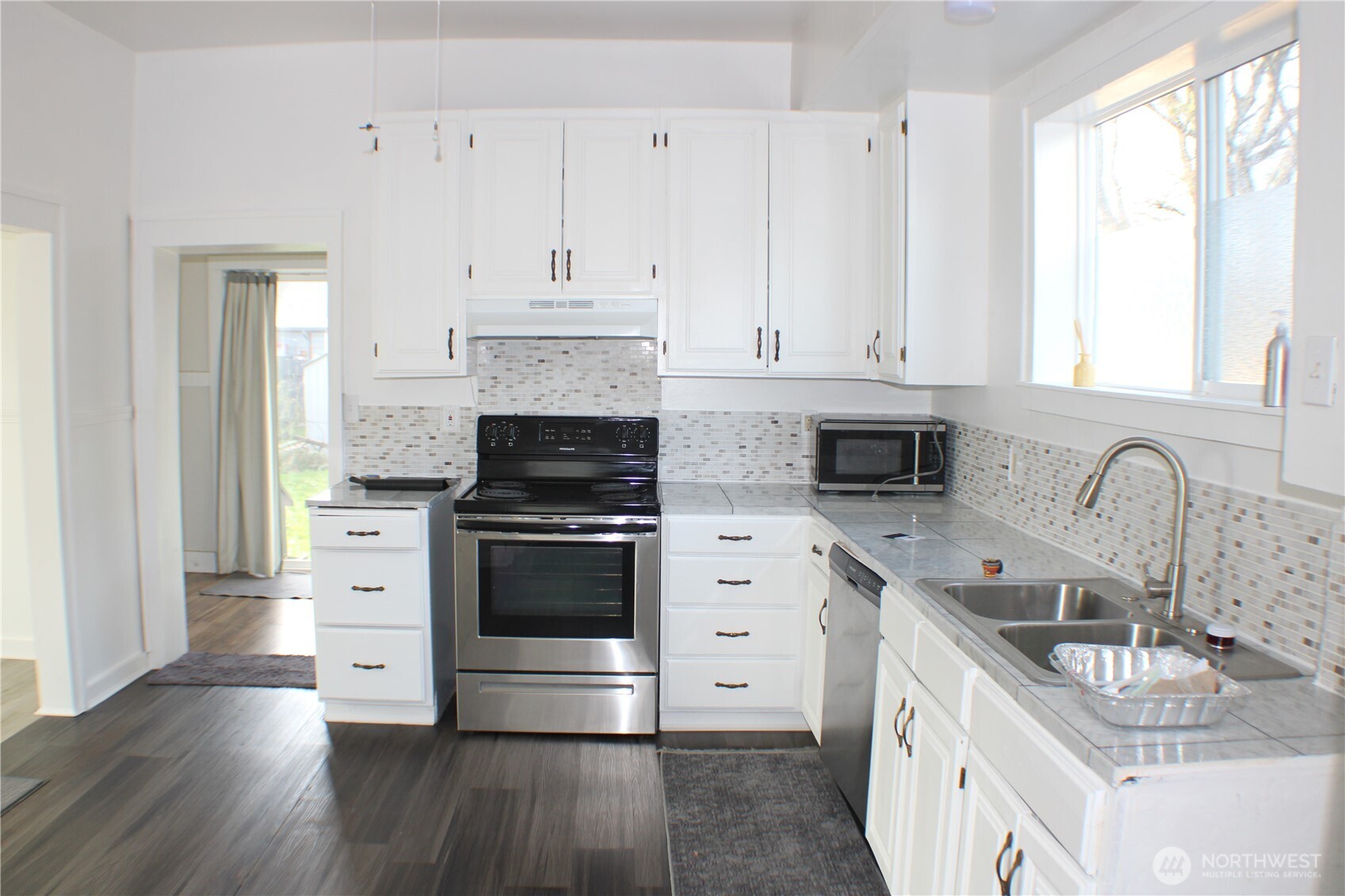 1224 4th Street Cosmopolis, WA 98537 - Photo 10 of 33 a kitchen with granite countertop a sink wooden floor and stainless steel appliances