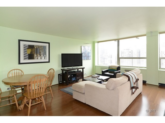1455 North Sandburg Terrace, Unit 1904 Chicago, IL 60610 - Photo 2 of 7 a living room with furniture a flat screen tv and a large window