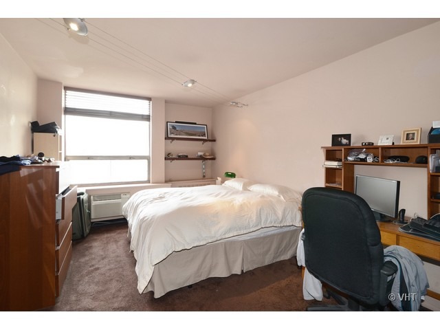 1455 North Sandburg Terrace, Unit 1904 Chicago, IL 60610 - Photo 6 of 7 a bedroom with a bed a couch and a window
