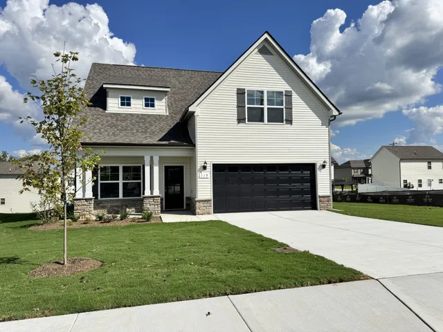 a front view of a house with a yard and trees