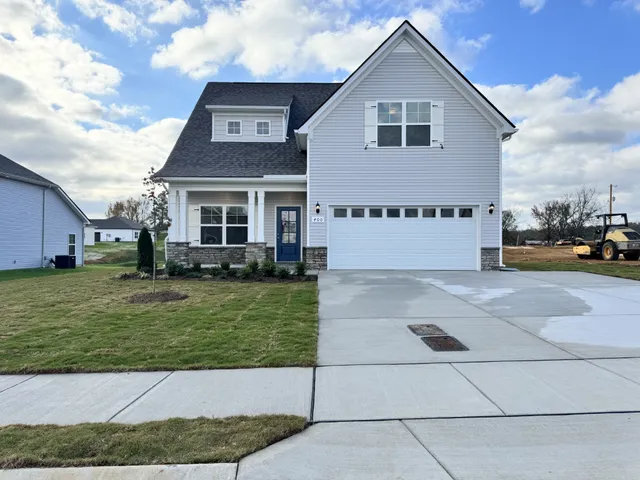a view of house and yard with car parked