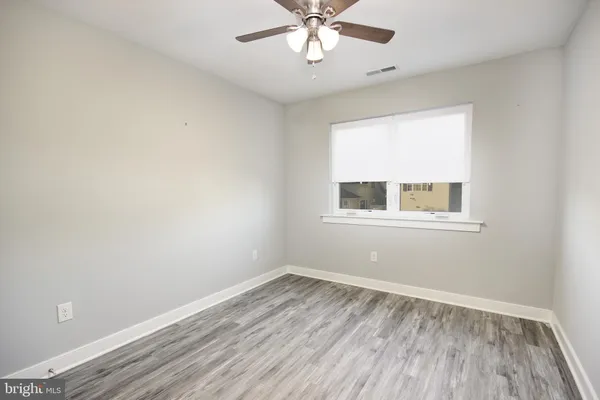 a view of a room with wooden floor and windows