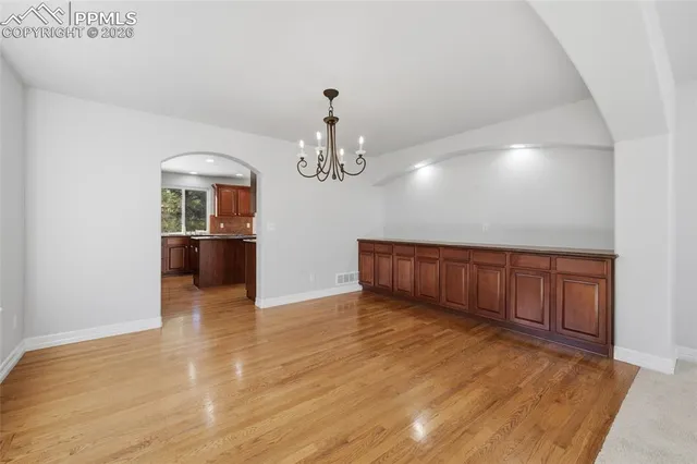 a view of a room with wooden floor and chandelier