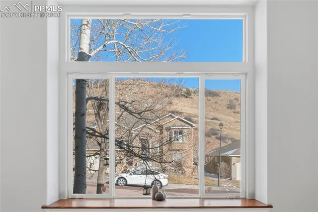 a view of a hallway with wooden floor and a kitchen