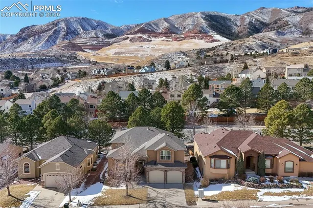 an aerial view of a house with a mountain