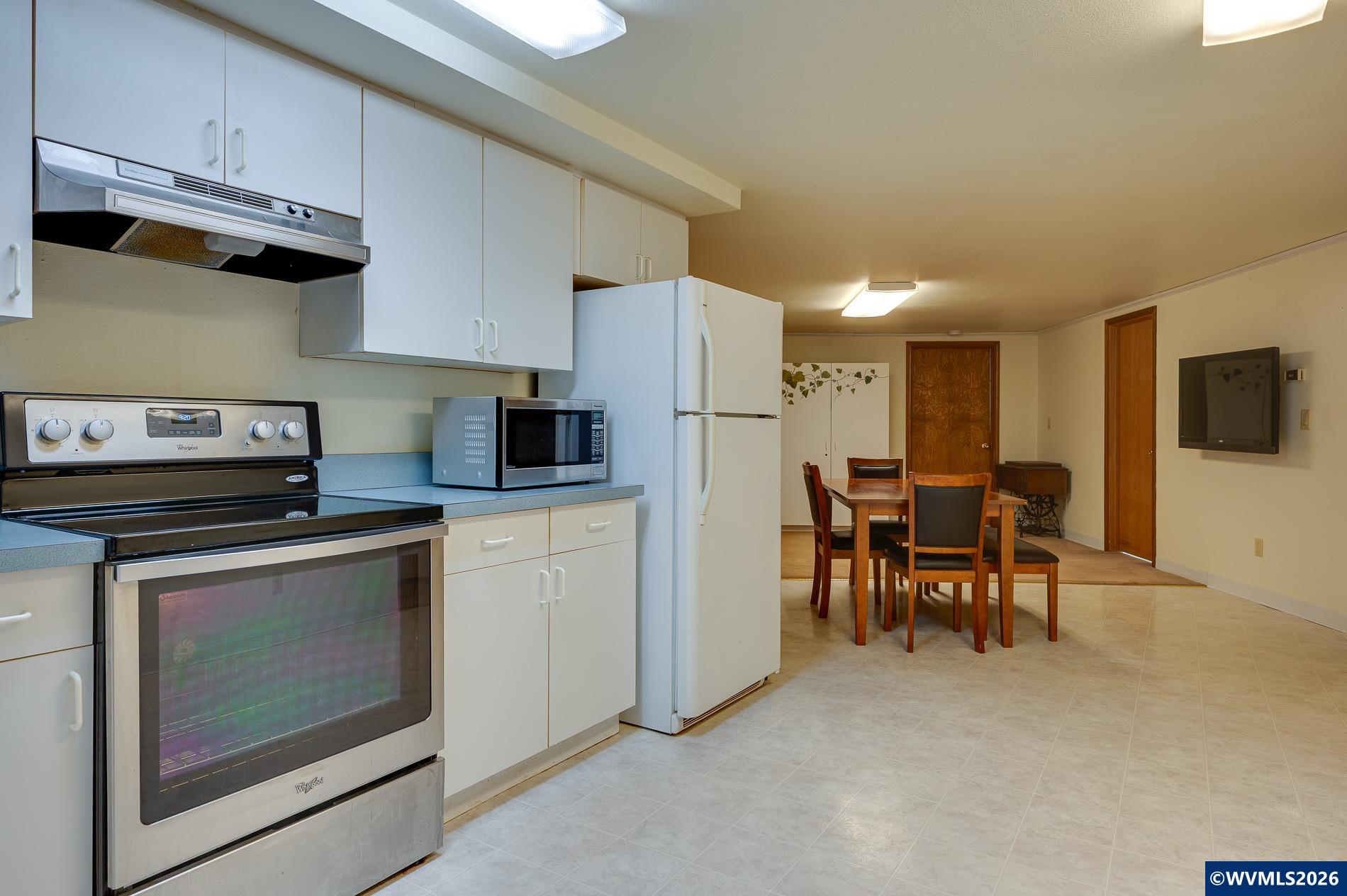 27572 South Kinzy Road Estacada, OR 97023 - Photo 37 of 50 a kitchen with stainless steel appliances granite countertop a stove top oven a refrigerator a sink and a dining table with wooden floor