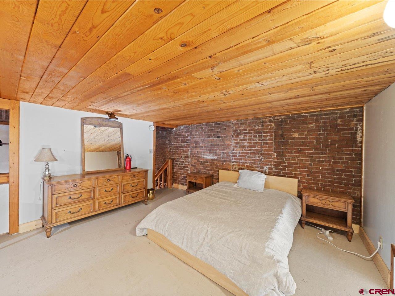 726 Main Street Ouray, CO 81427 - Photo 26 of 41 a bed room with a bed chair and wall painting