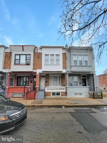 a view of an empty room with wooden floor and stairs