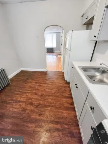 a kitchen with wooden floors and white appliances
