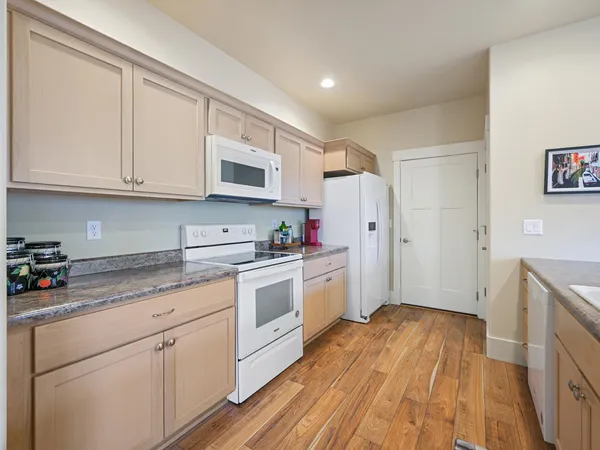 a kitchen with granite countertop wooden cabinets and white appliances