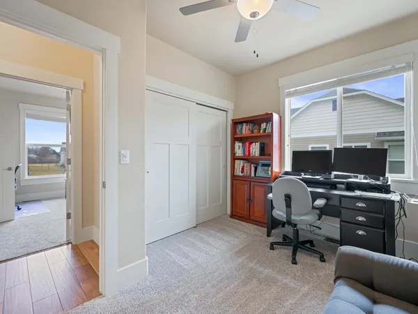 a view of a workspace with furniture and a window