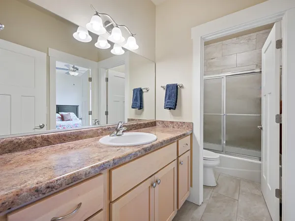 a bathroom with a granite countertop sink a toilet and a mirror