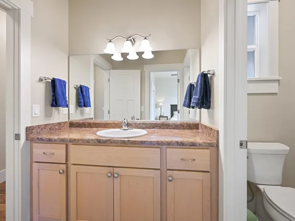 a bathroom with a granite countertop sink a toilet and a mirror