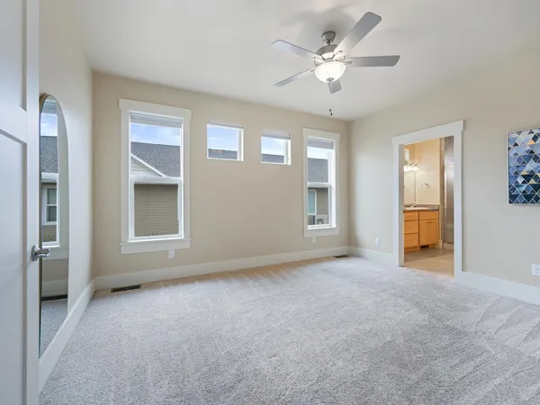 an empty room with fan and windows