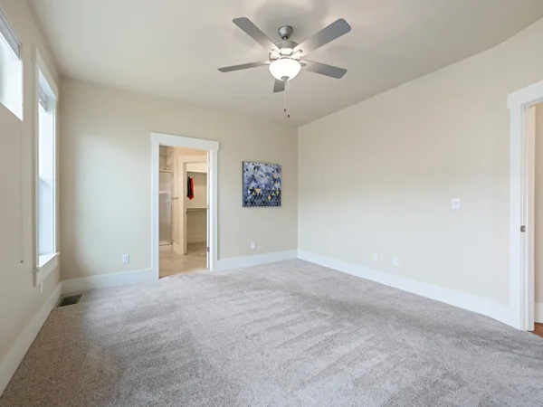 a view of a big room with chandelier fan and windows