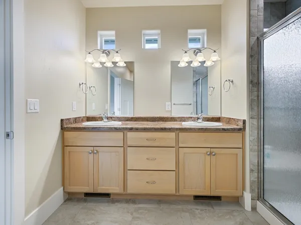 a bathroom with a double vanity sink and a mirror