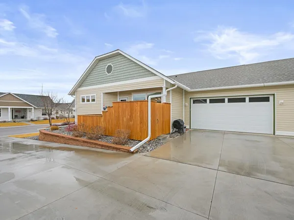 a backyard of a house with basket ball court and a garage