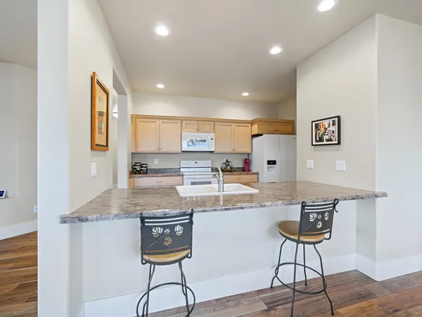 a kitchen with stainless steel appliances granite countertop a refrigerator and a stove top oven