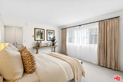 a bedroom with a large bed and a window