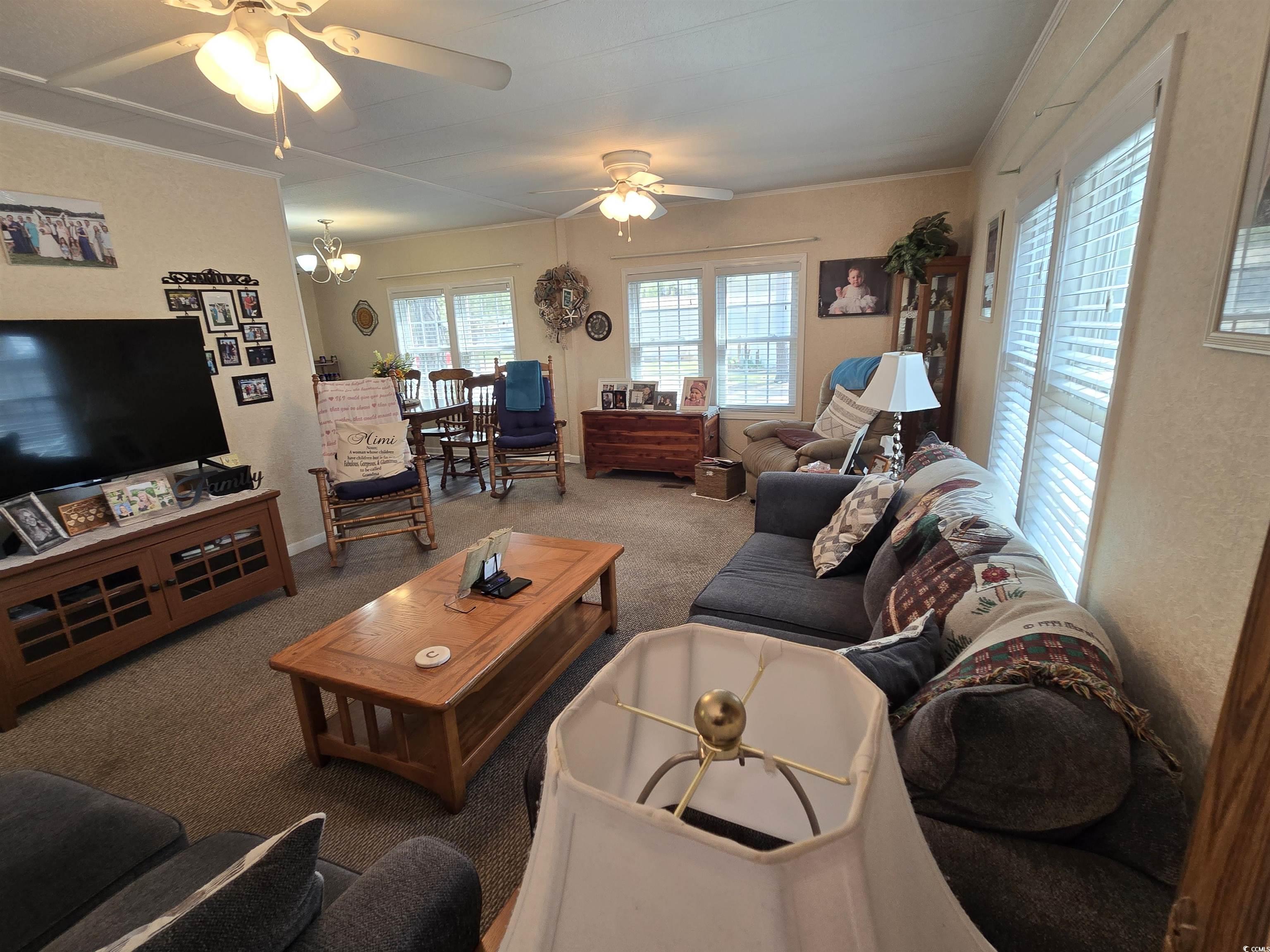 420 Delton Drive Murrells Inlet, SC 29576 - Photo 14 of 36 Living area featuring a ceiling fan, carpet flooring, a chandelier, and crown molding