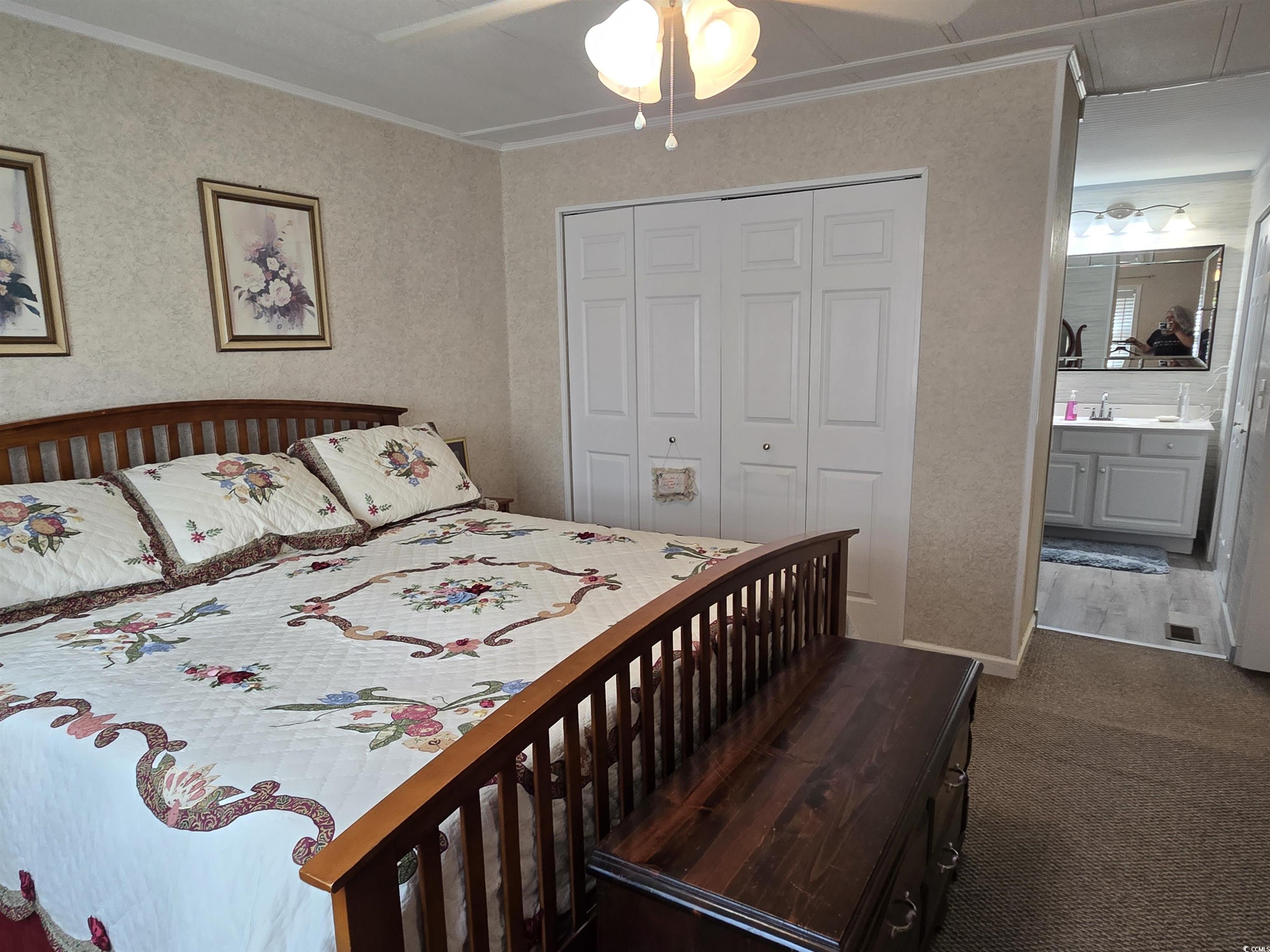 420 Delton Drive Murrells Inlet, SC 29576 - Photo 21 of 36 Bedroom with crown molding, ceiling fan, a closet, dark colored carpet, and wallpapered walls