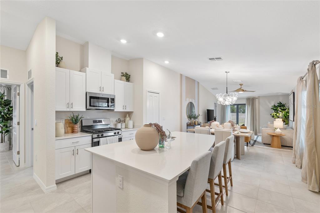 3707 Ambersweet Crossing Parrish, FL 34219 - Photo 1 of 26 a kitchen with stainless steel appliances a dining table chairs stove refrigerator and cabinets