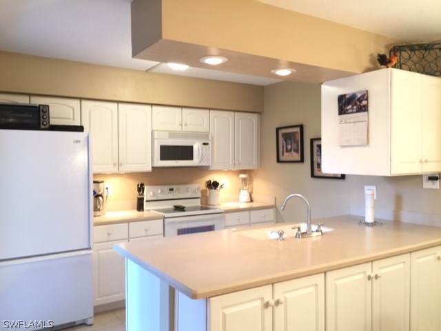 3021 Matecumbe Key Road, Unit 2 Punta Gorda, FL 33955 - Photo 9 of 24 a kitchen with stainless steel appliances a sink a stove a refrigerator a counter top and cabinets