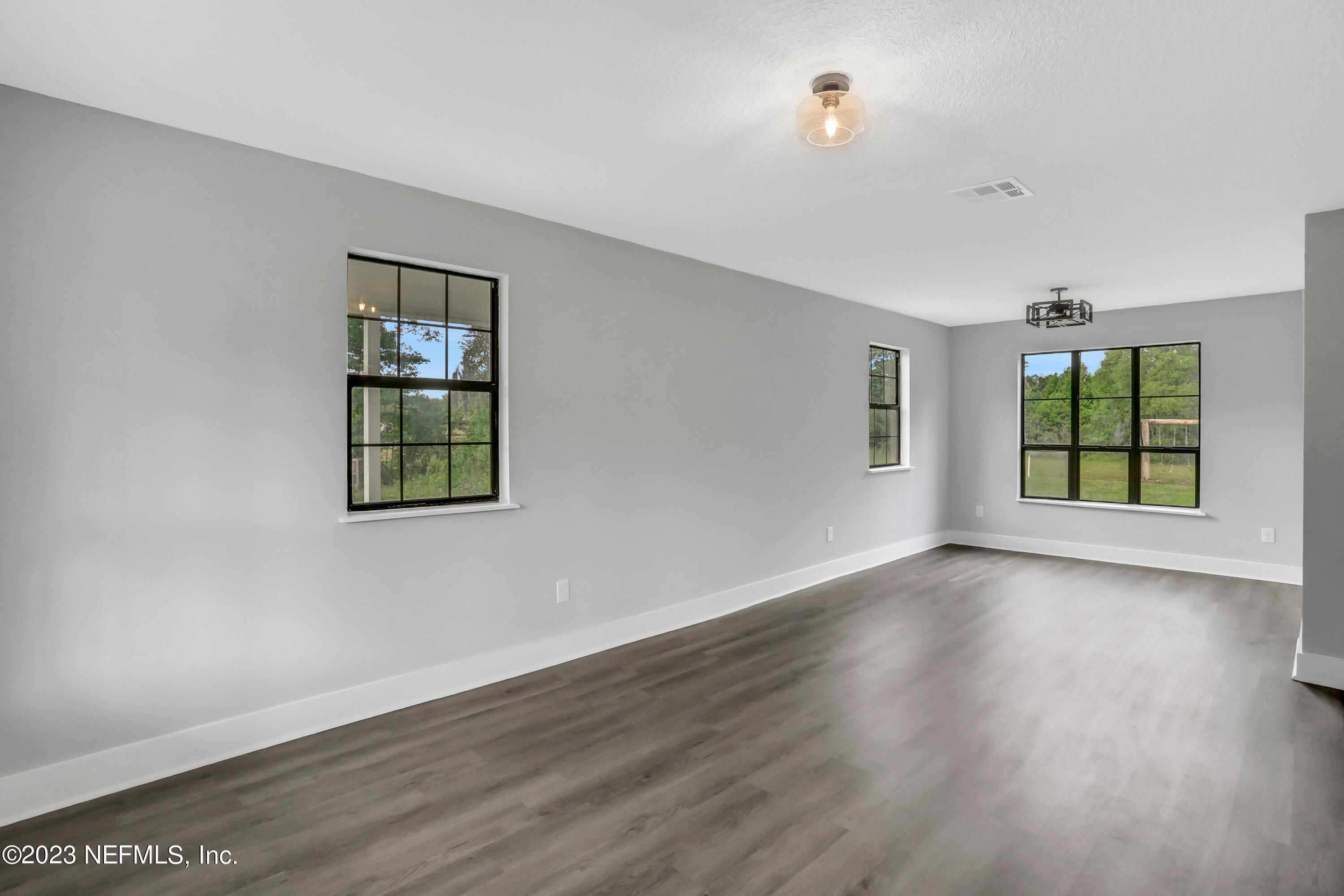 45195 Browns Farm Road Callahan, FL 32011 - Photo 8 of 24 an empty room with wooden floor and windows
