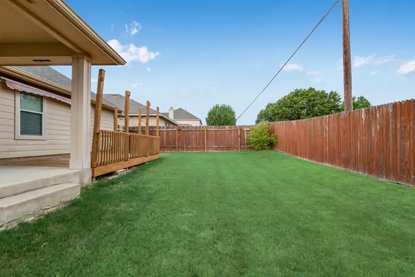 a view of backyard with barbeque and wooden fence