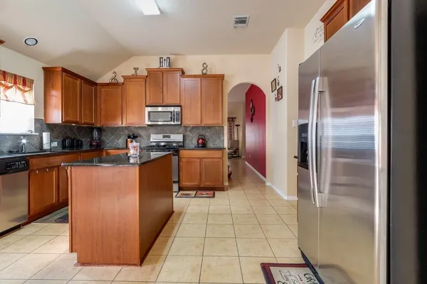 a kitchen with stainless steel appliances granite countertop a refrigerator and a stove