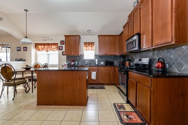 a kitchen with stainless steel appliances granite countertop a refrigerator and microwave