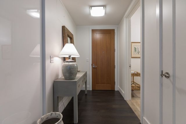 a view of balcony with a couple of cars parked in parking lot