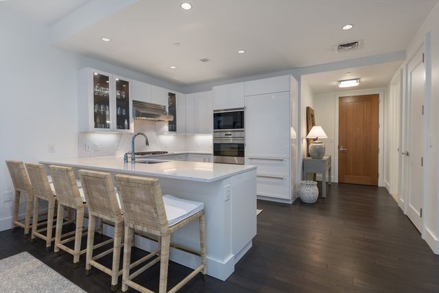 a kitchen with stainless steel appliances granite countertop a kitchen island hardwood floor and a sink