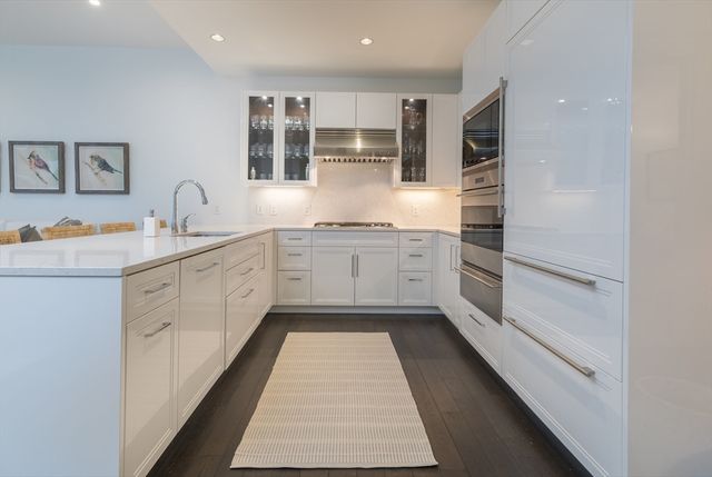 a kitchen with stainless steel appliances granite countertop white cabinets and window