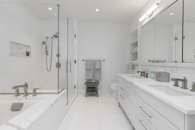 a spacious bathroom with a double vanity sink a mirror and a shower