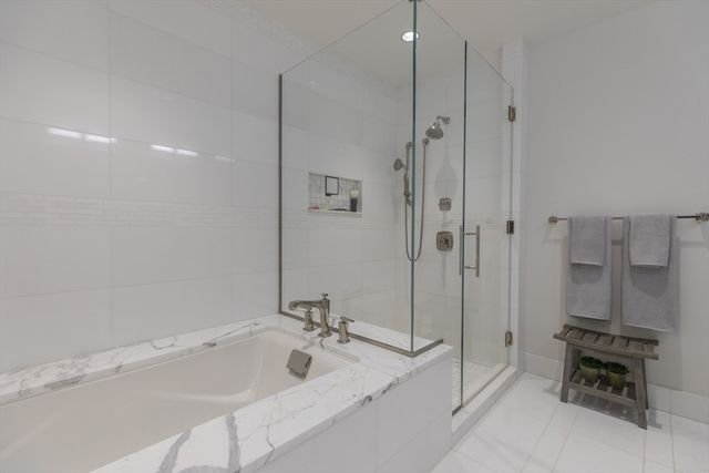 a bathroom with a tub sink mirror and a shower
