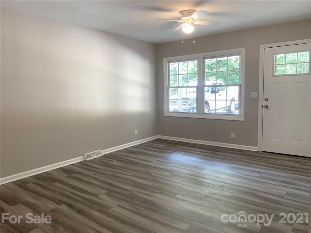 259 Roberta Road Concord, NC 28027 - Photo 3 of 12 an empty room with wooden floor and windows