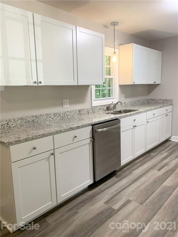 259 Roberta Road Concord, NC 28027 - Photo 4 of 12 a kitchen with granite countertop white cabinets and white stainless steel appliances