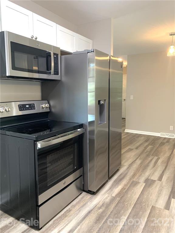 259 Roberta Road Concord, NC 28027 - Photo 5 of 12 a kitchen with stainless steel appliances granite countertop a stove microwave and refrigerator