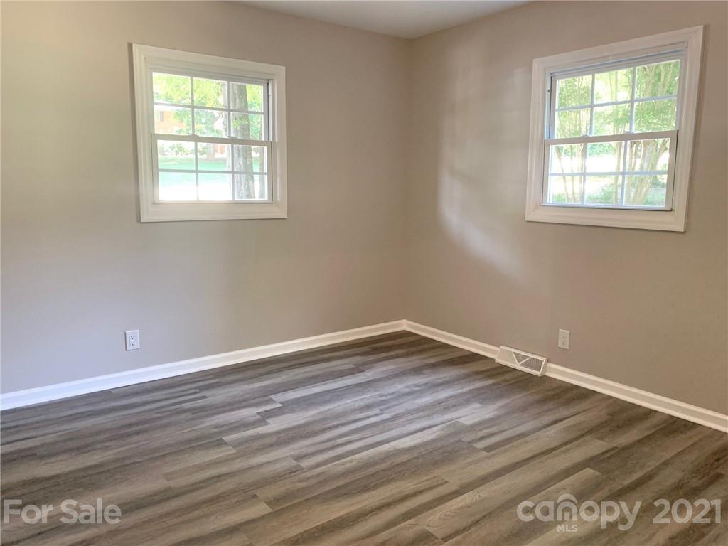 259 Roberta Road Concord, NC 28027 - Photo 8 of 12 an empty room with wooden floor and windows