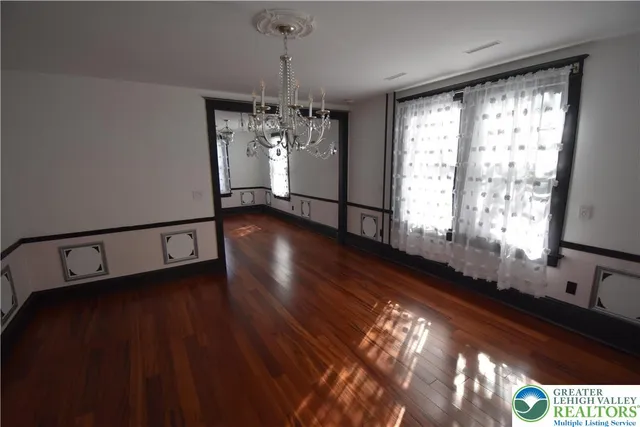 a view of a room with wooden floor stairs and windows